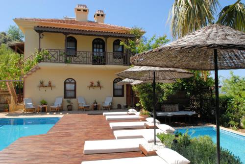 a villa with a swimming pool and a resort at Mandarin & Mango Boutique Hotel in Faralya