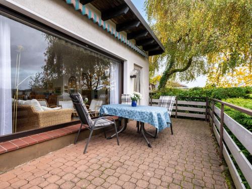einen Tisch und Stühle auf einer Terrasse in der Unterkunft Holiday home in Langscheid with panoramic view in Langscheid