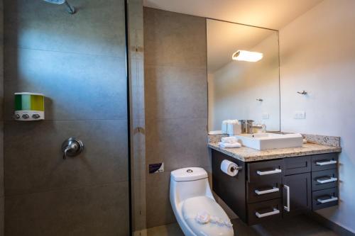 a bathroom with a toilet and a sink and a shower at Best in Jaco Condos at Diamante del Sol in Jacó