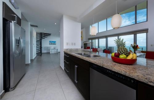 a kitchen with a bowl of fruit on a counter at Best in Jaco Condos at Diamante del Sol in Jacó