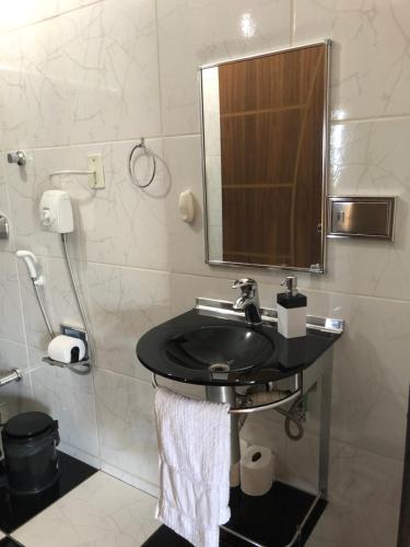 een badkamer met een wastafel en een douche bij Casa Acaraí in São Francisco do Sul