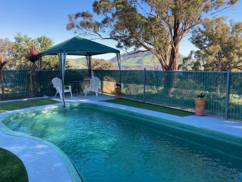 a swimming pool with a gazebo in a yard at Burnt Creek Cottages in Mansfield