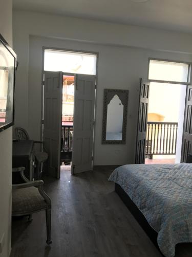 a bedroom with a bed and a desk and two windows at 310Guest-House La Vida in San Juan