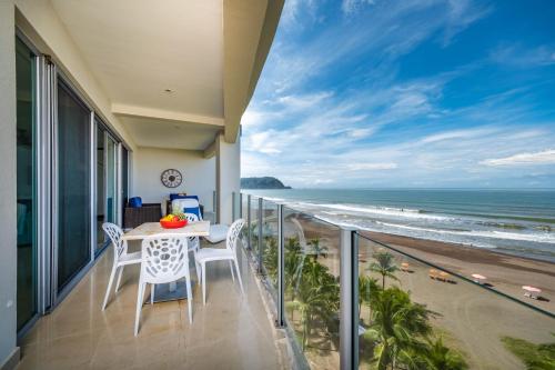 a balcony with a table and chairs and the ocean at Best in Jaco Condos at Diamante del Sol in Jacó