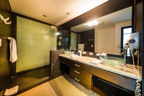a bathroom with two sinks and a large mirror at Best in Jaco Condos at Diamante del Sol in Jacó