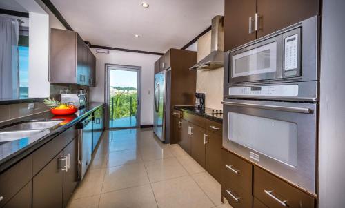 a kitchen with stainless steel appliances and brown cabinets at Best in Jaco Condos at Diamante del Sol in Jacó
