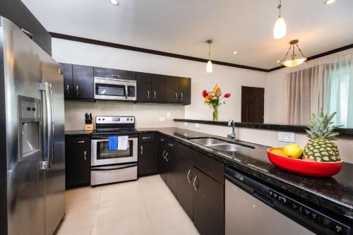 a kitchen with black cabinets and a bowl of fruit on the counter at Best in Jaco Condos at Diamante del Sol in Jacó