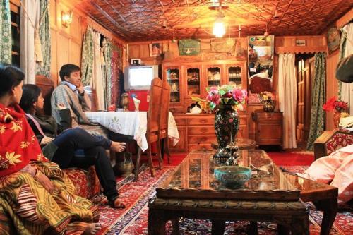 a group of people sitting in a living room at Houseboat Pride of India in Srinagar