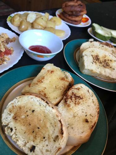 a table with plates of food with bread on them at Tenam Garden homestay in Kalimpong