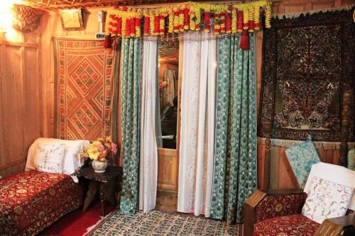 a bedroom with a bed and a window with curtains at Houseboat Pride of India in Srinagar