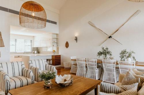 a living room with chairs and a table and a clock at WATERFRONT in Dunsborough