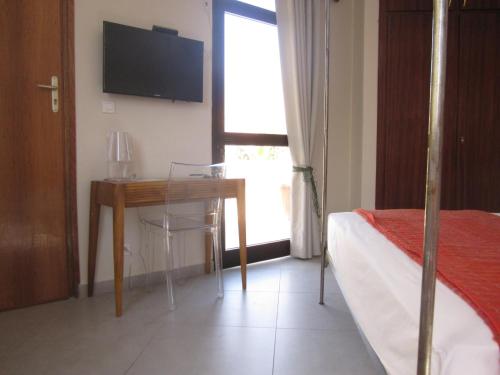 a bedroom with a bed and a table and a television at La Villa 126 Dakar in Dakar