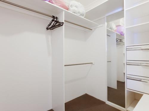 a white walk in closet with white cabinets at Carindale, 13 19 Dowling Street - Ground floor unit with complex pool and tennis court in Nelson Bay