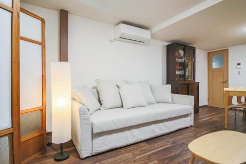 a living room with a white couch and a table at Private house En Sagisu #OF1 in Osaka