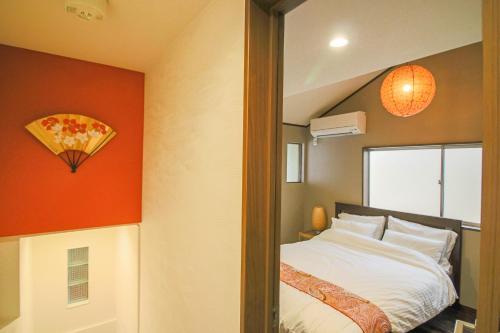 a bedroom with a bed and an orange wall at Private house En Sagisu #OF1 in Osaka