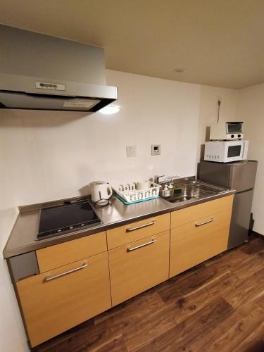 a kitchen with a sink and a stove and a microwave at Private house En Sagisu #OF1 in Osaka
