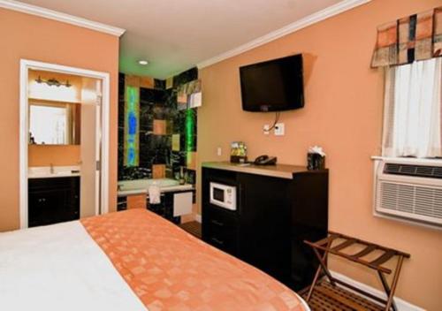 een slaapkamer met een bed en een badkamer met een televisie bij The Prince Hotel in Tunkhannock