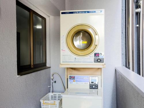 a washer and dryer in a room next to a window at Business Hotel Sunpalace in Tokyo