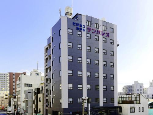 a building with a sign on the side of it at Business Hotel Sunpalace in Tokyo