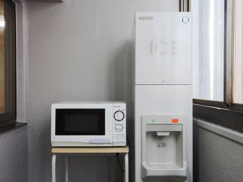 a microwave sitting on a table next to a water dispenser at Business Hotel Sunpalace in Tokyo