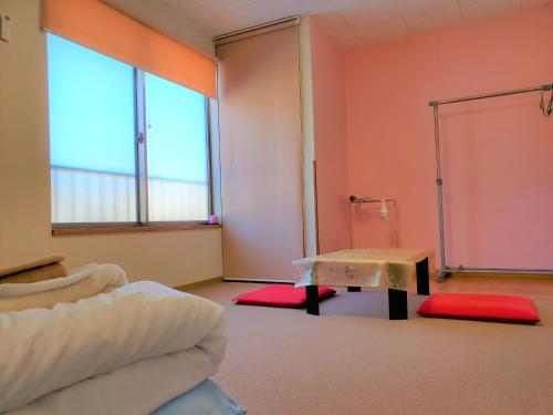 直島的住宿－雅多七海灘酒店，一间配有沙发、一张桌子和两个窗户的客房