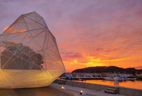 a sculpture in front of a marina at sunset at Yado Seven Beach in Naoshima