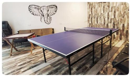 a ping pong table in a room with a drawing on the wall at Arthigamya Beach Front Resort & SPA in Gokarna