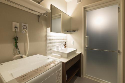a bathroom with a sink and a washing machine at GRAND BASE Kagoshima Tenmonkan in Kagoshima
