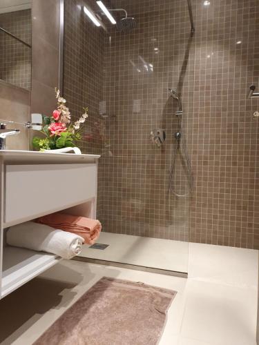 uma casa de banho com um chuveiro e um lavatório. em Lovely Apartment in Jebel Sifah with private Garden - As sifah em Mascate