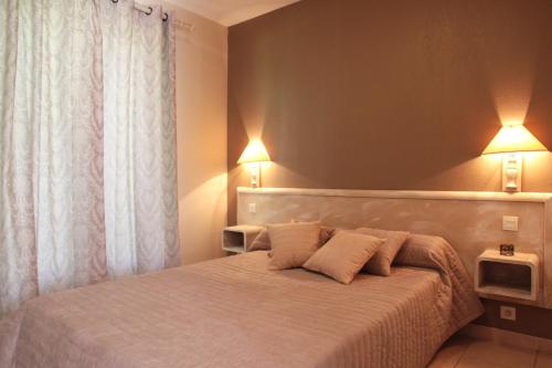 ein Schlafzimmer mit einem Bett mit zwei Lampen in der Unterkunft Domaine Les 4 Vents in Patrimonio