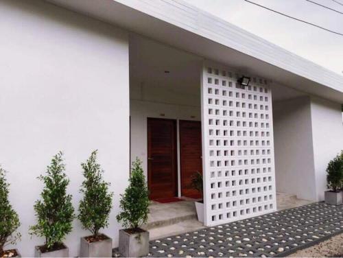 a white house with potted plants in front of it at My home resort - ขนอม นครศรีธรรมราช in Khanom