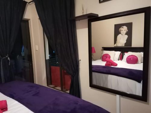 a mirror reflecting a bedroom with a bed with purple sheets at Sancta Maria 10 - Ultimate in luxury & majestic sea views includes private entertainment deck - Free wifi in Kingsburgh