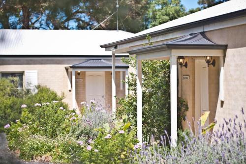 a house with purple flowers in front of it at Encounter Hideaway Cottages in Encounter Bay