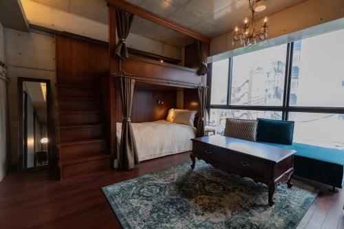 a bedroom with a bed and a couch and a table at Creare Ryogoku in Tokyo