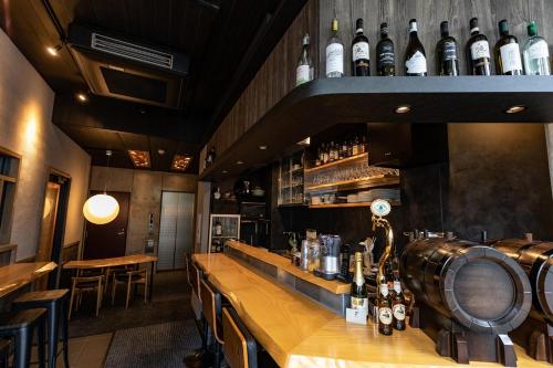 a bar with a bunch of bottles on the wall at Creare Ryogoku in Tokyo