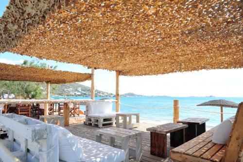 a patio with tables and chairs and a view of the ocean at Medusa Beach Resort & Suites in Plaka