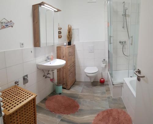 a bathroom with a sink and a toilet and a shower at Ferienwohnung in Birkenwerder mit Balkon in Birkenwerder