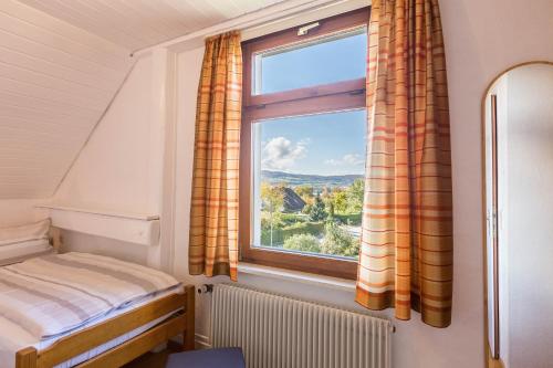 a bedroom with a bed and a window at Ferienwohnung zum Seeblick in Öhningen