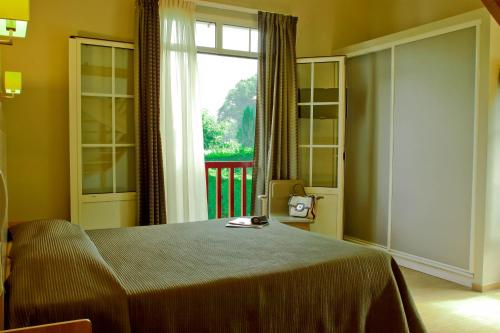a bedroom with a bed and a large window at Hotel Restaurant Txistulari in Itxassou