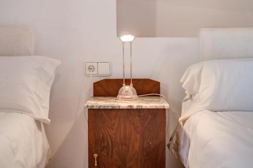 a lamp on a night stand next to two beds at Possessio Sa Barrala Casa del Pages in Campos