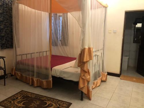 a bedroom with a canopy bed and a rug at Impala Safari Lodge in Voi