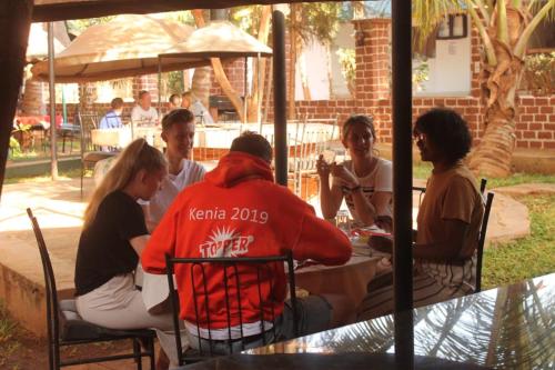 a group of people sitting around a table at Impala Safari Lodge in Voi