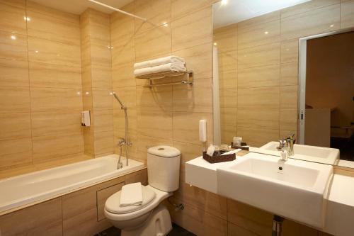 a bathroom with a toilet and a sink and a tub at Hotel Six Seasons @ Mid Valley in Kuala Lumpur