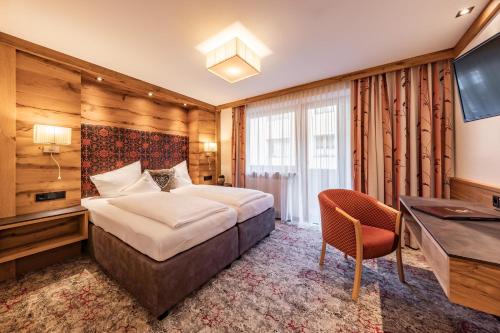 a hotel room with a bed and a desk at Hotel Pramstraller in Mayrhofen