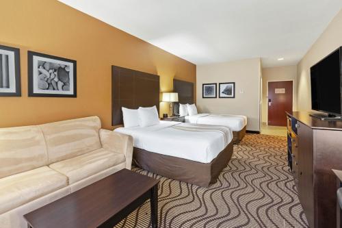 a hotel room with two beds and a couch at La Quinta by Wyndham South Bend in South Bend