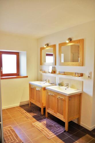 une salle de bain avec deux lavabos et deux miroirs dans l'établissement Domaine Joseph LAFARGE Wine Resort B&B, à Lugny
