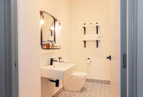 a bathroom with a white toilet and a sink at Goodstay Apartments by Urban Space in Barry