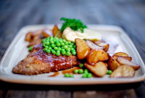 a plate of food with meat potatoes and peas at Mountain Lodge in Stöten