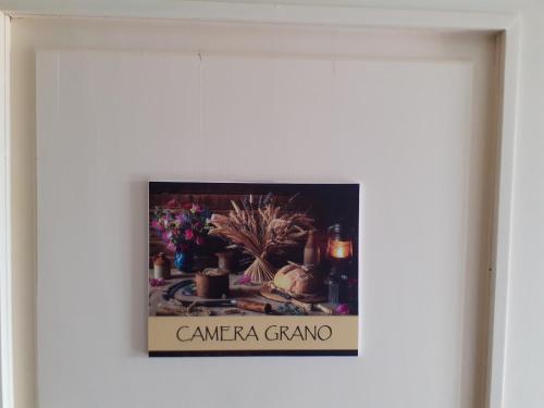 a picture in a frame on a wall at Cascina Merlo Country House in Pareto