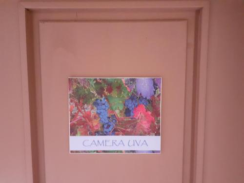 a sign on a door with a picture of grapes at Cascina Merlo Country House in Pareto